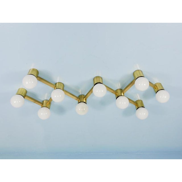 A striking mid-century light sculpture from the 1970s, suitable both as a flush-mount ceiling chandelier and as a wall-...