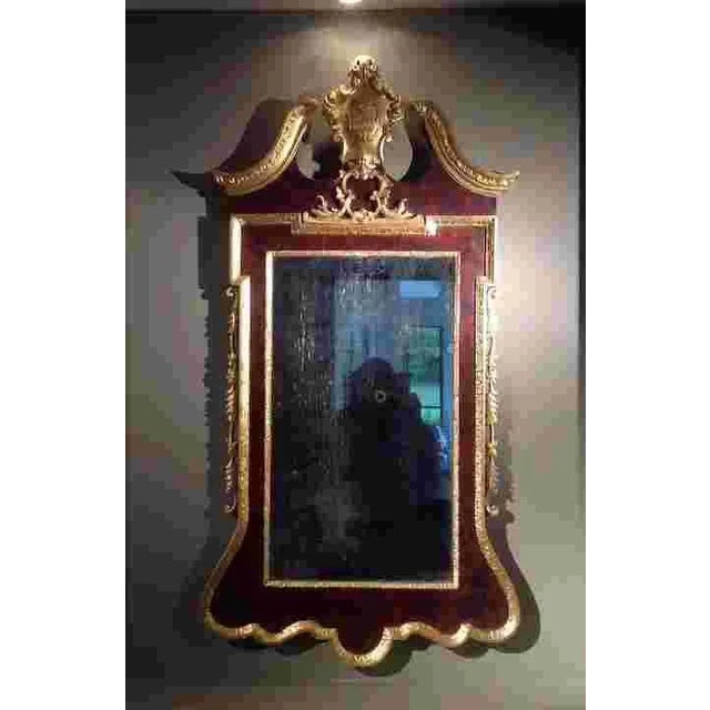 A scarce George II carved giltwood burl walnut wall mirror, c. 1750. Has the classic broken pediment design with a central...