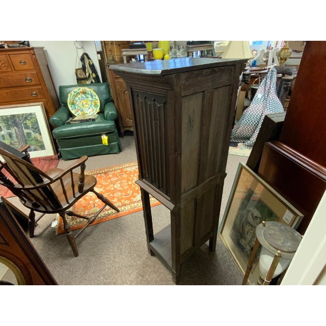 19th century gothic cabinet with open bottom shelf. Geometric carved design on leg base, figure and floral design on door....