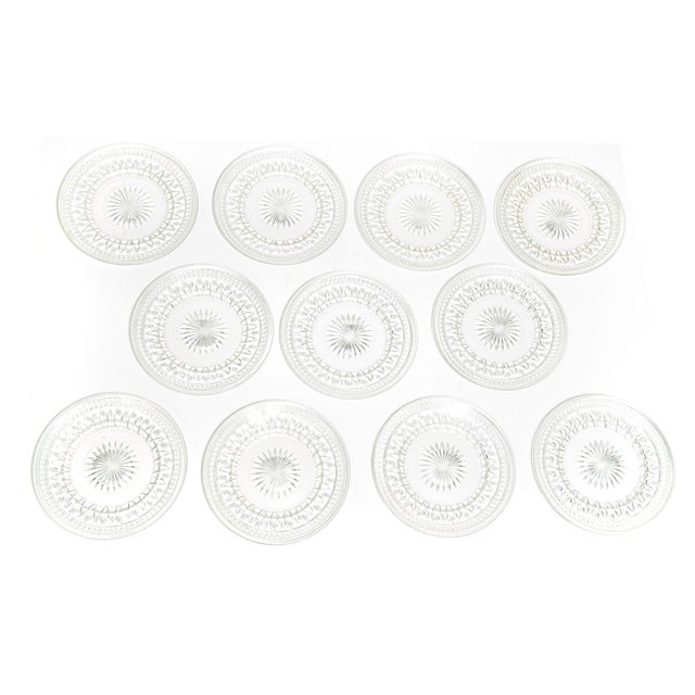 Beautiful mid century era set of 11 vintage pressed glass plates featuring an eye-catching starburst and geometric cut...