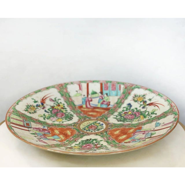 Large hand-painted Chinese Rose Canton charger plate having an arrangement of birds, flowers, butterflies and traditional...