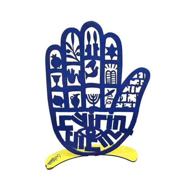 This is a freestanding David Gerstein metal sculpture titled "Hamsa Besorot Tovot" (Good News), featuring vibrant, hand-...