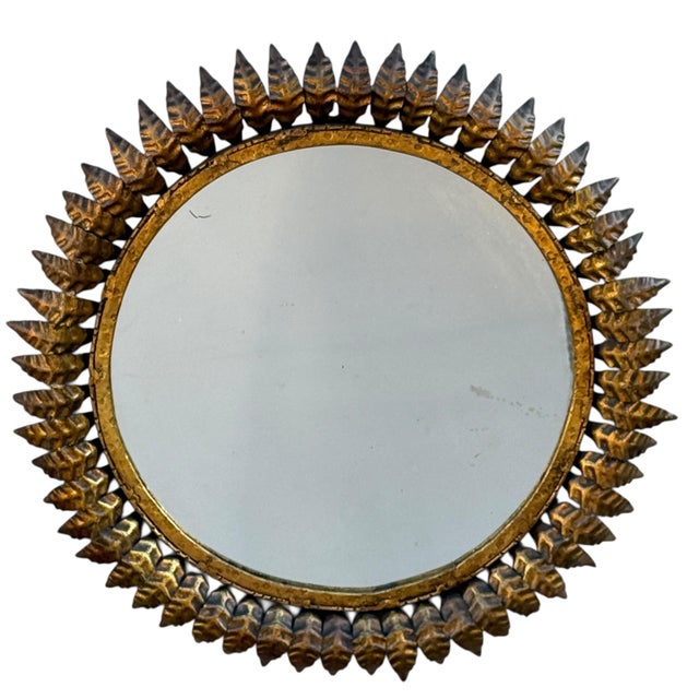 Magnificent round wrought iron sunburst mirror from the 1950s. Italian handcrafted, decorated with leaves.