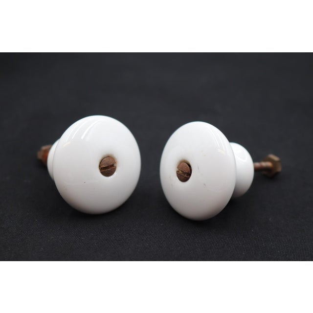 Vintage cabinet or drawer knobs made of white ceramic with a round shape. Mounting screws are included. Good condition...