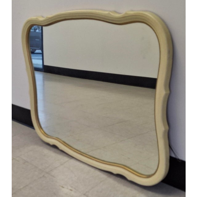 A Mid Century French Provincial Style Cream Painted Frame Wall Mirror. Measures 40" in width, 2" in depth and stands 30"...