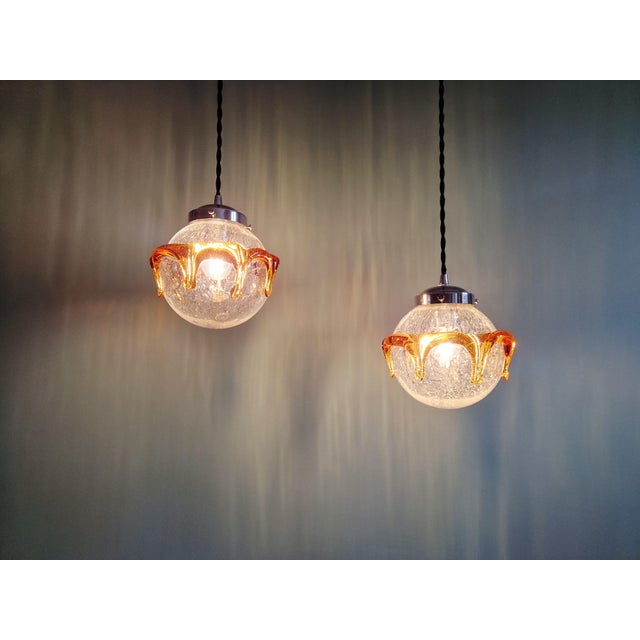 Pair of space age pendant lights in clear, bubble-blown murano glass with an amber glass lava layer, 1970s. each pendant...