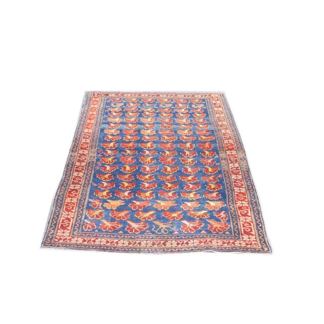 Five reversing rows of profile carnation detailed in red and cream decorate the lightly abrashed royal blue field of this...