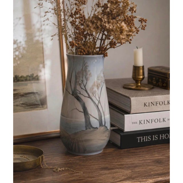 Porcelain vase produced by bing & grøndahl in denmark. executed with a hand-painted landscape motif in muted earth tones...