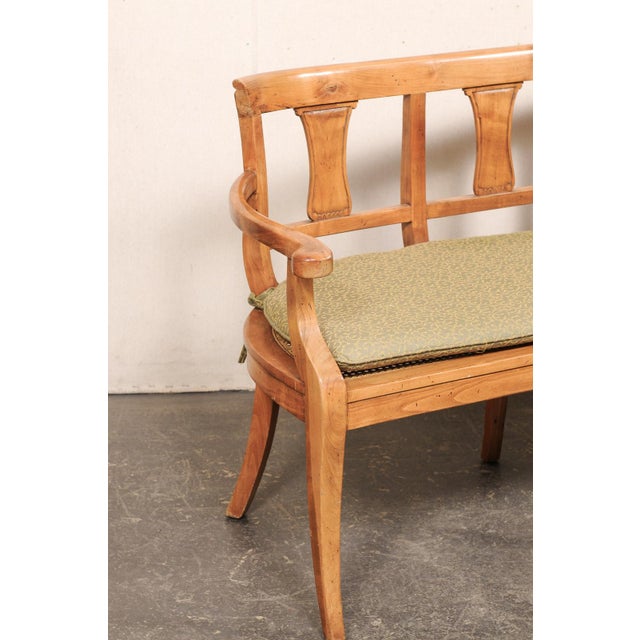 An Italian three-chair back fruitwood sofa bench, with cane seat and cushion, from the mid 20th century. This vintage...