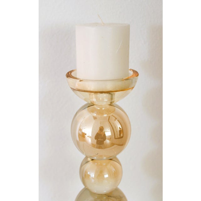 A modern spin on mid-century, this lucite candle holder has a uniquely stacked globe shaped design. We love it's faint...