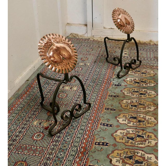 A pair of Arts & Crafts copper and iron fire dogs or fire dogs This very stylish pair of cast iron fire dogs with a large...