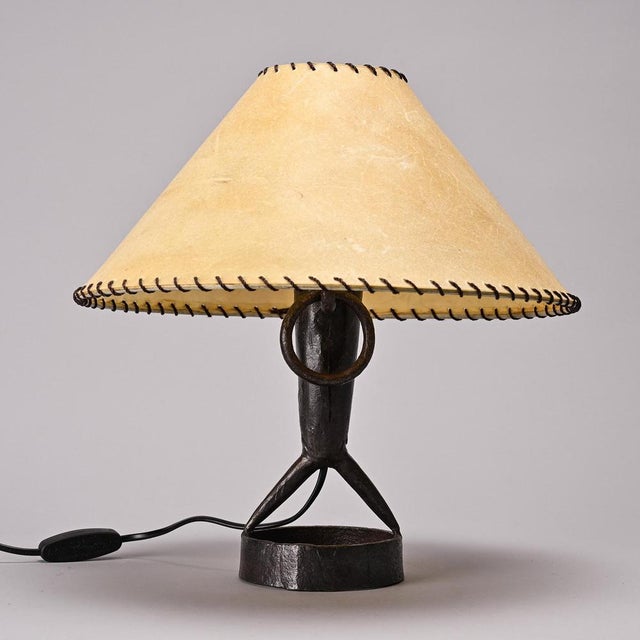 Table lamp in hammered iron by Léopold Gest, made in France around 1970. It rests on a circular wrought iron base and...