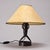 Table lamp in hammered iron by Léopold Gest, made in France around 1970. It rests on a circular wrought iron base and...