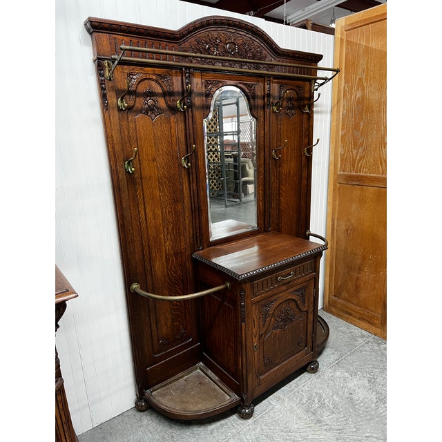A striking antique Victorian hall tree crafted in richly grained oak with elaborage carved detailing throughout. This...