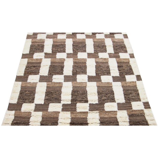 This beautifully made wool rug showcases a contemporary Moroccan pattern in a calming Ivory shade, artfully set against a...