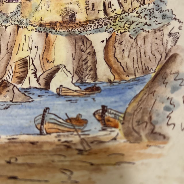 This charming ceramic hanging plate captures the serene beauty of a coastal landscape through delicate, hand-painted...