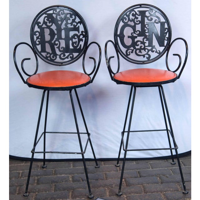 The swinging 1960s! Two 1960s wrought iron stools by Arthur Umanoff, Rye and Gin with orange vinyl seats. Seat height is...