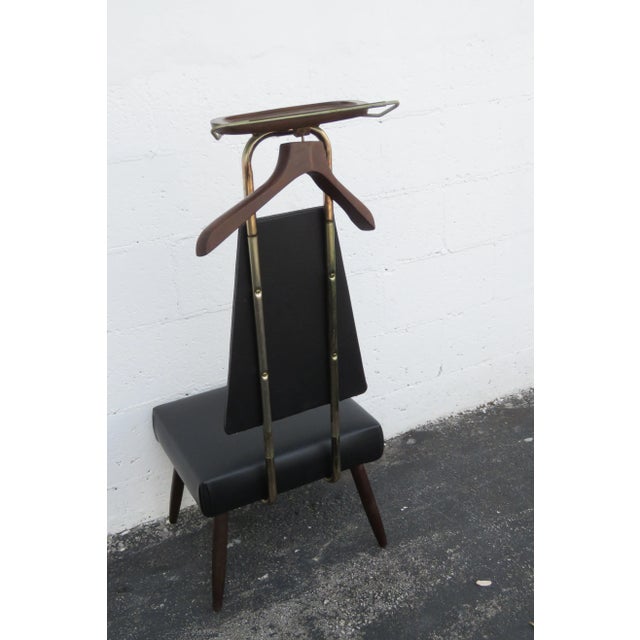 This Vintage Mid Century classic Butler or Gentleman's Valet is made of wood, metal, vinyl, and is in good condition. It...