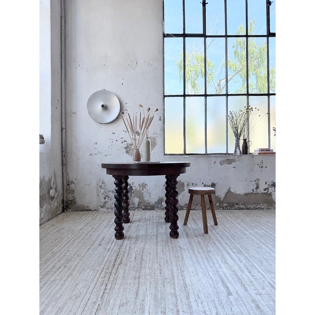 Antique table from 1900, made entirely of solid walnut. Composed of a very thick round top and a spool-style base, its...
