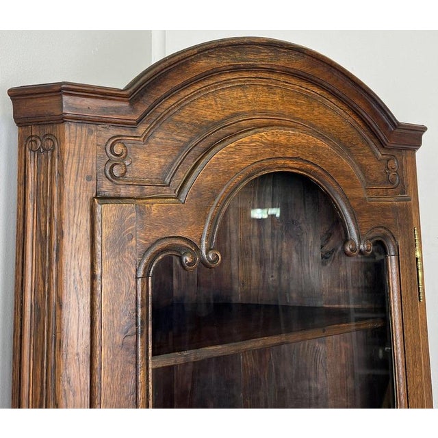 This elegant Vintage French Oak Corner Bookcase is a charming space-saving display cabinet that combines practical storage...