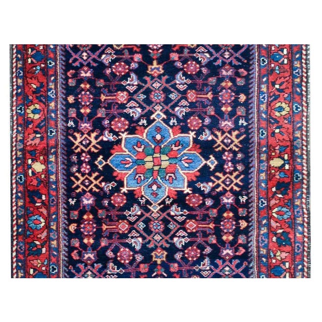 A striking early 20th century Persian Bibikibad rug with an all-over stylized floral and scrolling vine pattern woven in...
