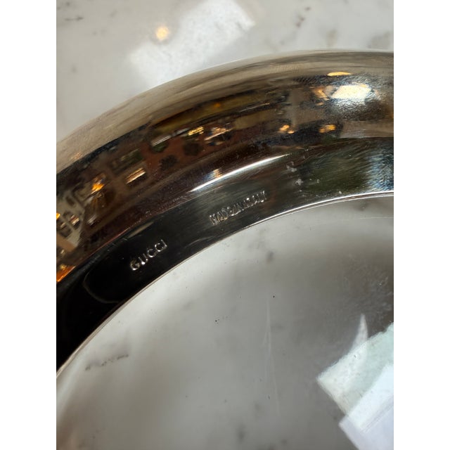 Elegant vintage Gucci clear glass bowl featuring gold-tone metal banding, silver-tone wrapped details, and the iconic...