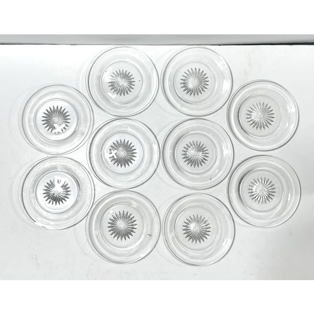 An elegant set of ten vintage Heisey crystal plates featuring a crisp starburst motif at the center and a clean,...