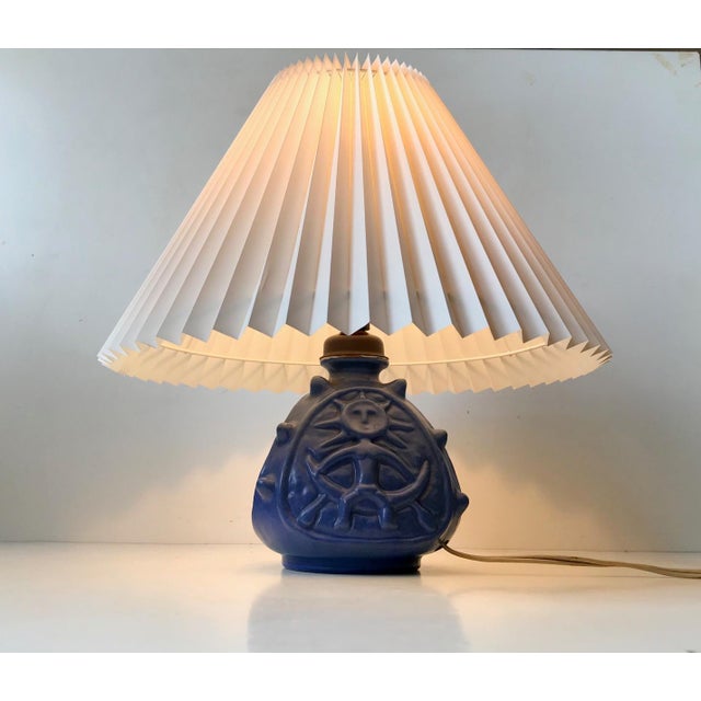 Blue glazed spiky ceramic table lamp with two sides with troll motifs. Designed and manufactured by Lauritz Hjorth on the...