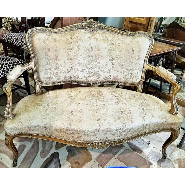 A French staple in any of the classes sitting rooms, this 1880-1890s French Louis XV style gilded settee with rococo...