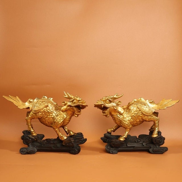 This is a matched pair of finely cast gilt bronze sculptures depicting Qilin, mythical hooved creatures revered in...