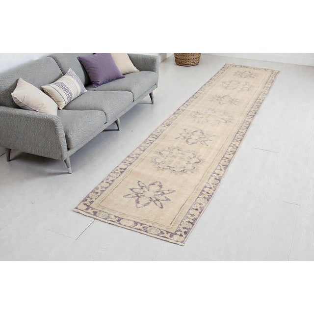 This is a vintage Turkish Oushak rug from the Mid 20th Century. The piece was hand-knotted.