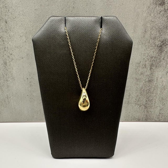This teardrop necklace is crafted in 10kt yellow gold and features a graceful teardrop pendant with a polished finish. The...