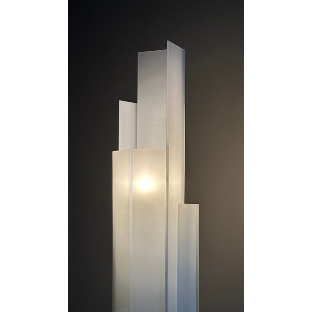 The floor lamp Adubai, produced by Fontana Arte design by Matteo Nunzianti. The lamp has an opaline white tempered glass...