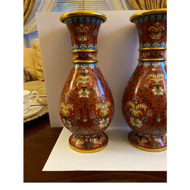 This pair of cloisonné enameled vases was created in Japan, mid-20th century. Each vase with elegant form features a gilt...