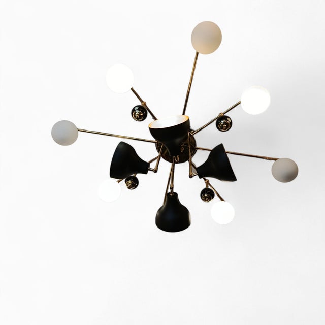 This Stilnovo-style ceiling lamp combines black brass spotlights, white blown-glass shades, and glossy black Murano glass...