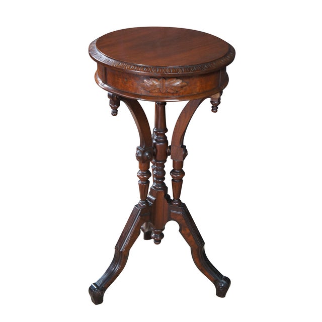 An antique Victorian era Eastlake parlor pedestal table or plant stand, circa 1880s. Made from walnut with a round top...