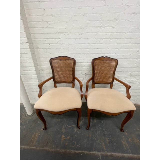 A pair of early 21st century Queen Anne style armchairs with cane backs, upholstered seats and cabriole legs. No maker’s...