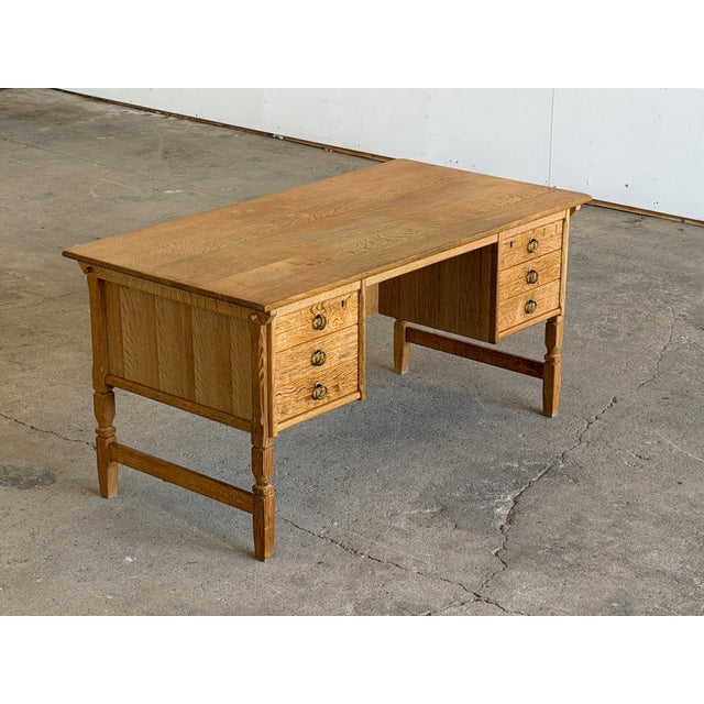 A danish oak pedestal writing desk designed by henning kjærnulf, bearing the original eg kvalitetsmøbel label on the...