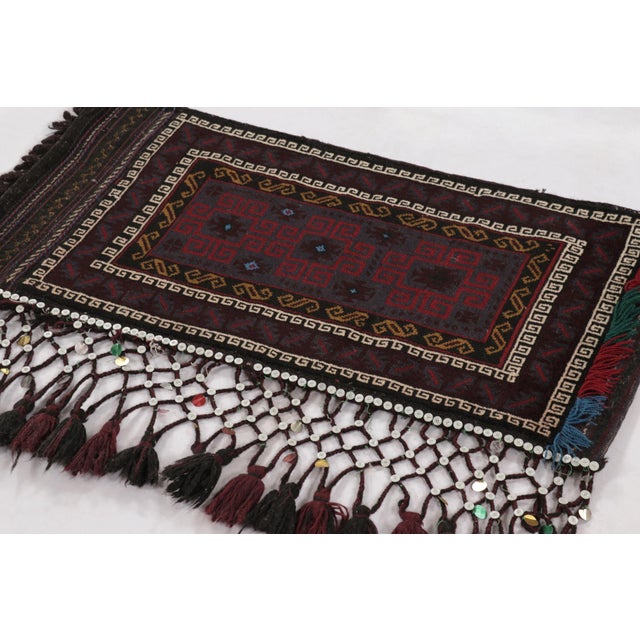Hand-knotted in wool, this 2x4 vintage Pakistani rug from circa 1950-1960 is a compelling example of tribal craftsmanship,...