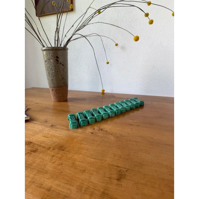 A set of 12 antique vallauris-style green ceramic knife rests with woven patterns. we love their slightly kitsch look,...