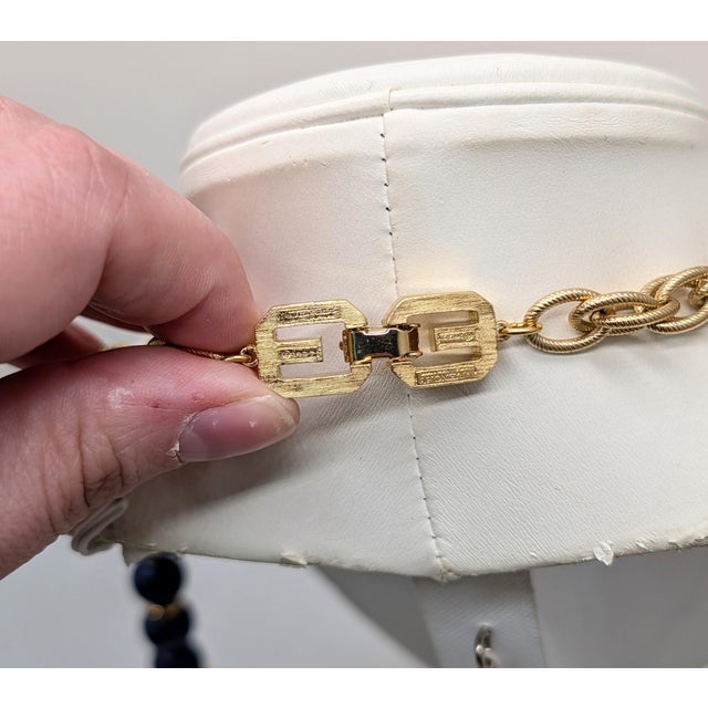 Goldtone navy blue resin beaded sautoir necklace with GGs around the fold over clasp. Marked "GIVENCHY PARIS NEW YORK" and...