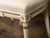 A pair of English Neoclassical style painted wood side chairs from the early 20th century with parcel gilt décor and...