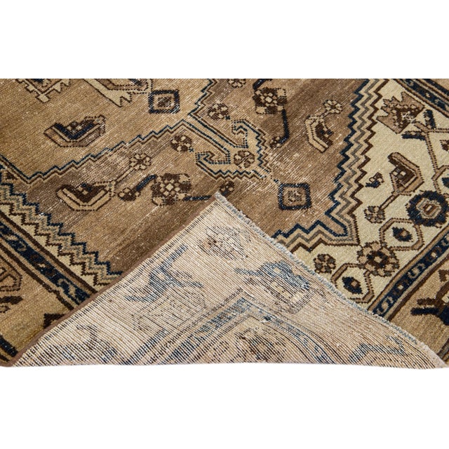 Beautiful Vintage Distressed hand-knotted wool rug with a brown field. This Persian rug has black and beige accents in an...