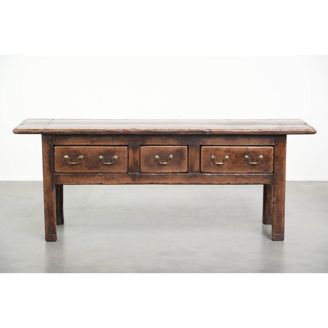 This sturdy antique English-style sideboard from the 19th century has a beautiful country look and a stunning patina. It...
