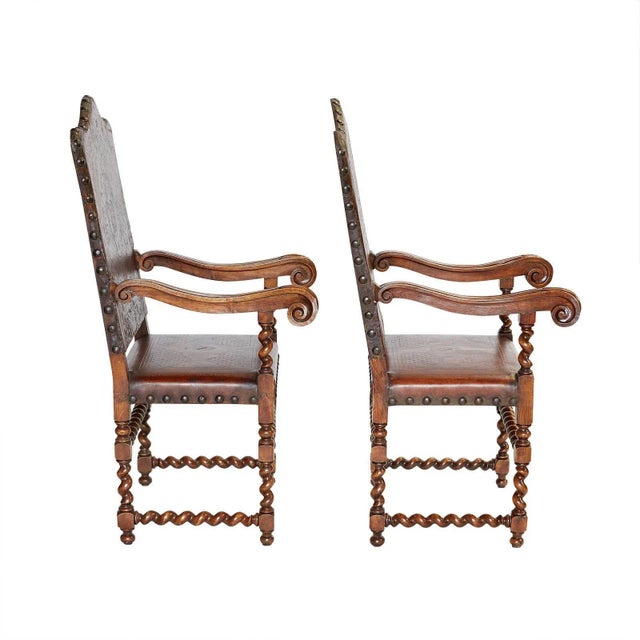 A pair of Spanish walnut armchairs covered in leather