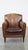 Charming and characteristic subtle patinated sheep leather armchair finished with decorative nails and piping. This...