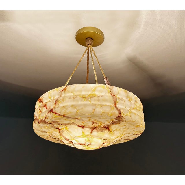Art Deco pendant light with a mottled glass shade in hues ranging from white to maroon with translucent yellow patches...