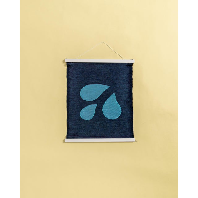 This textile wall piece is elegantly framed within a wooden magnetic frame, allowing it to float freely while showcasing...