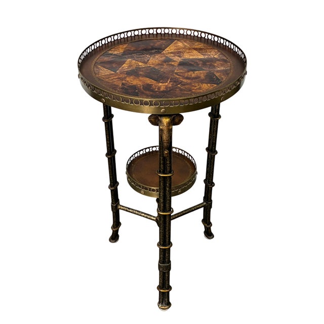 Distinctive vintage two-tier accent table dating to the late 20th century, featuring an exotic faux-bamboo metal frame...
