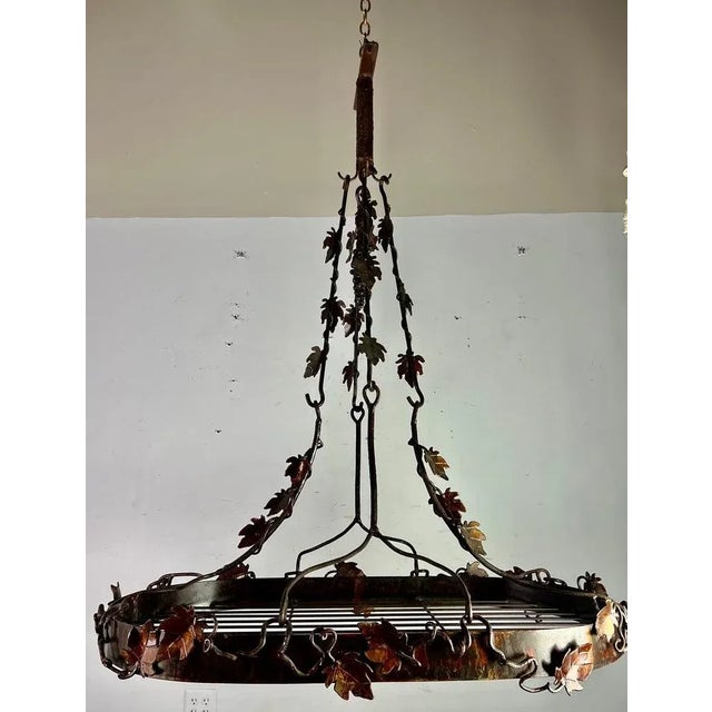 20th Century hand forged wrought iron pot rack with decorative vines and leaves throughout. It was hand made out of iron...